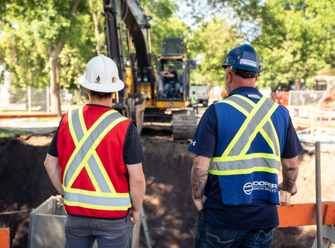 Construction workers observe rental equipment in operation on a jobsite. Cooper Equipment Rentals trench safety division adheres to a high level of safety guidelines.
